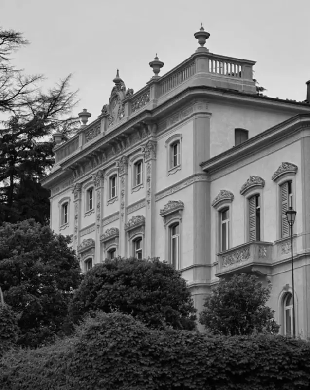 Grand hotel exterior with manicured gardens, black and white