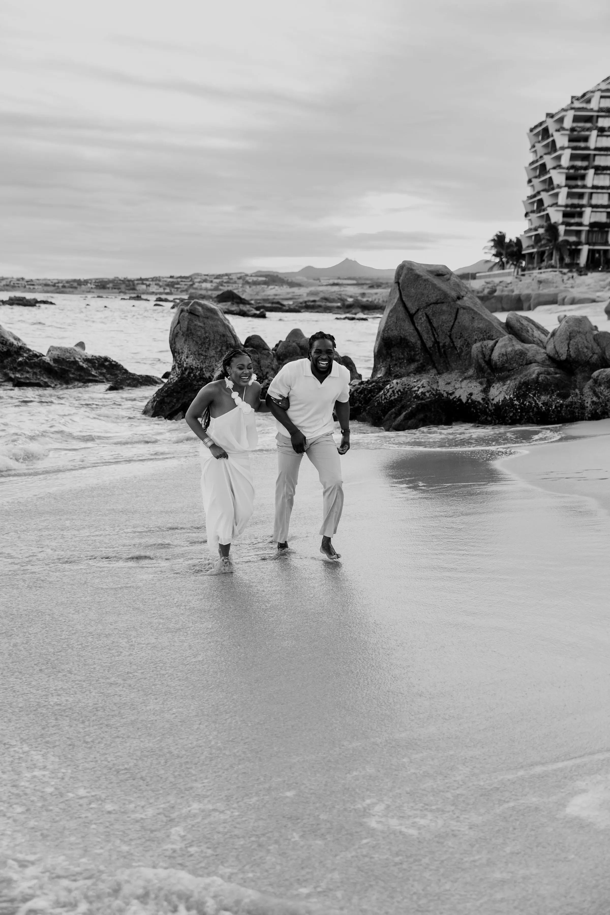 Temiloluwa and Olugbenga running together on the beach, black and white